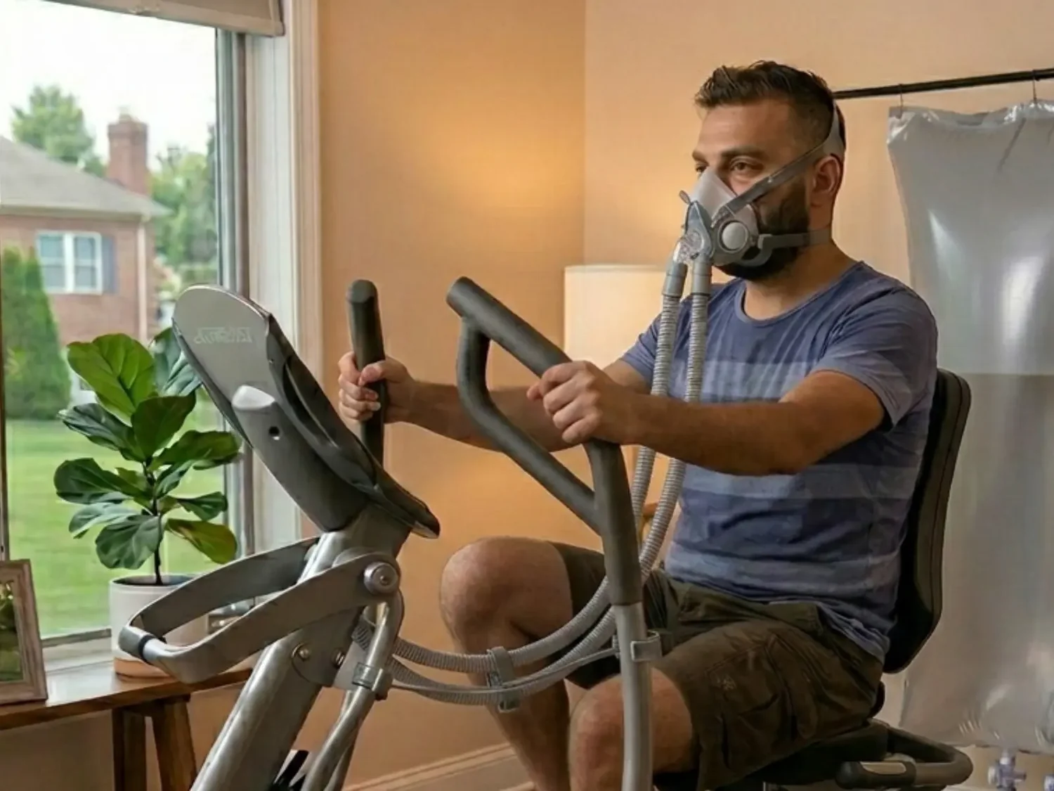 Man using an oxygen mask while exercising on a stationary bicycle at home